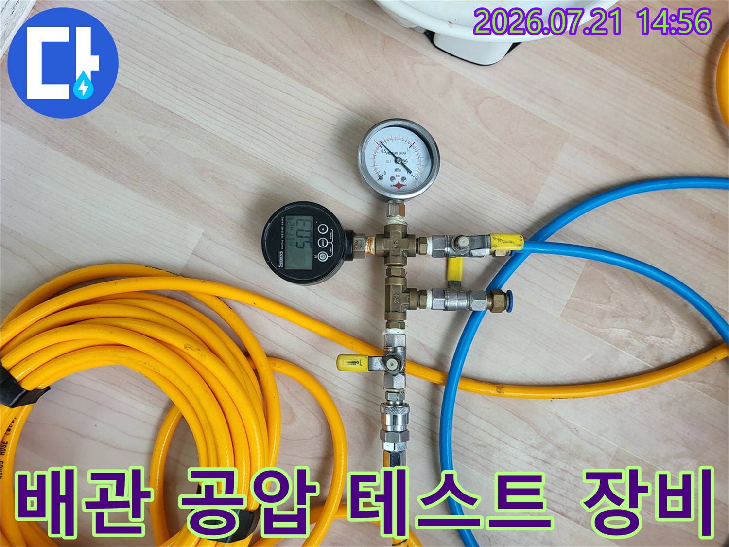 온수배관 압력 점검용 게이지와 호스가 연결된 모습