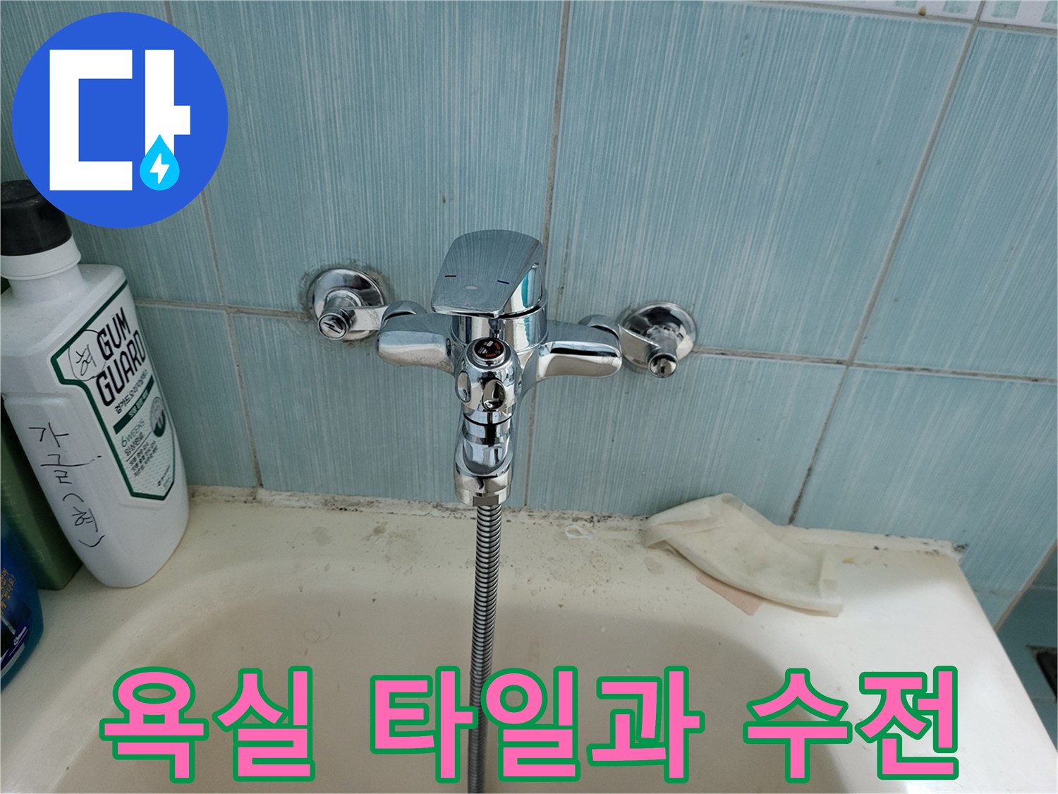 파란색 타일 벽면의 수도꼭지 및 샤워 호스