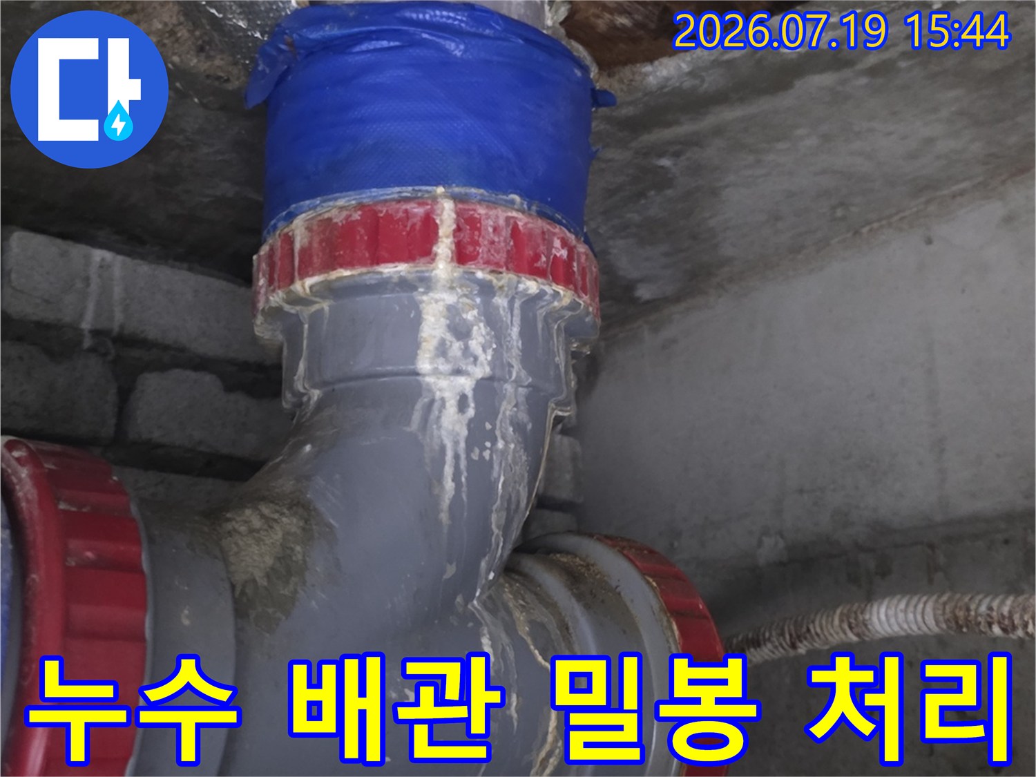 천장의 좁은 공간에서 PVC 배관 연결 부위를 교체하고 보강재로 감싼 현장 사진
