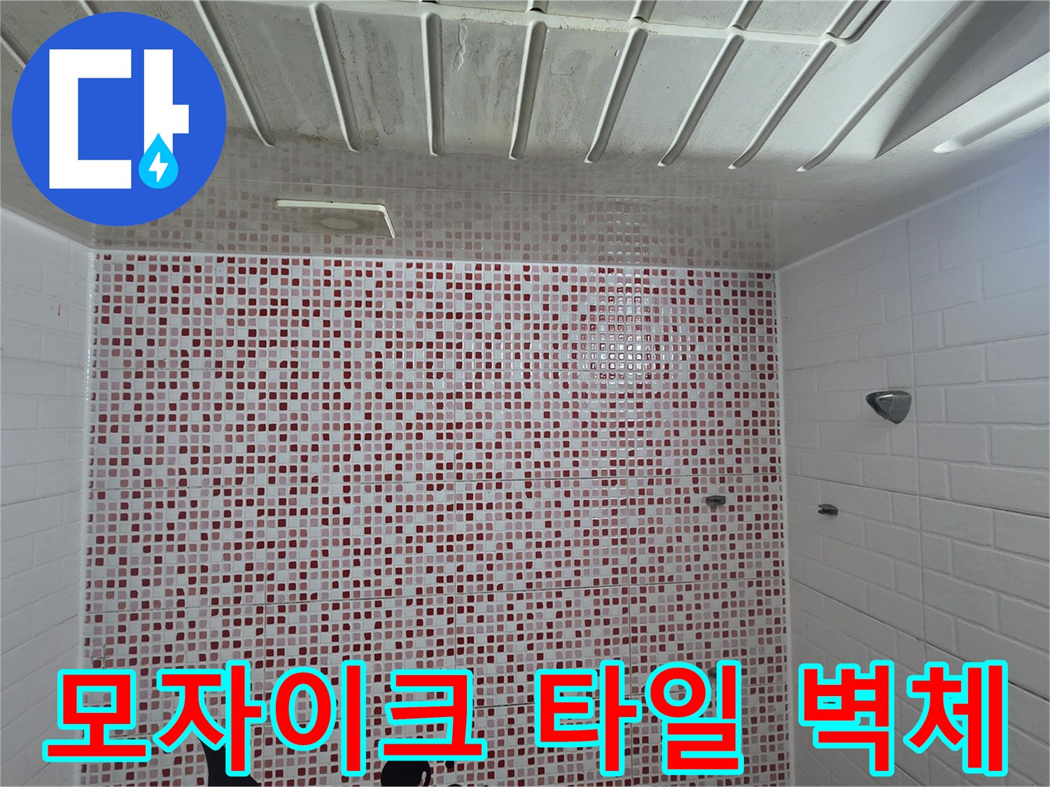 화장실 내부의 모자이크 패턴 타일과 천장 구조물