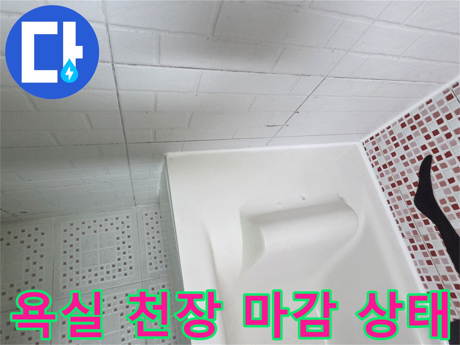 화장실 내부의 천장 패널과 타일 벽면 접합부 모습입니다.