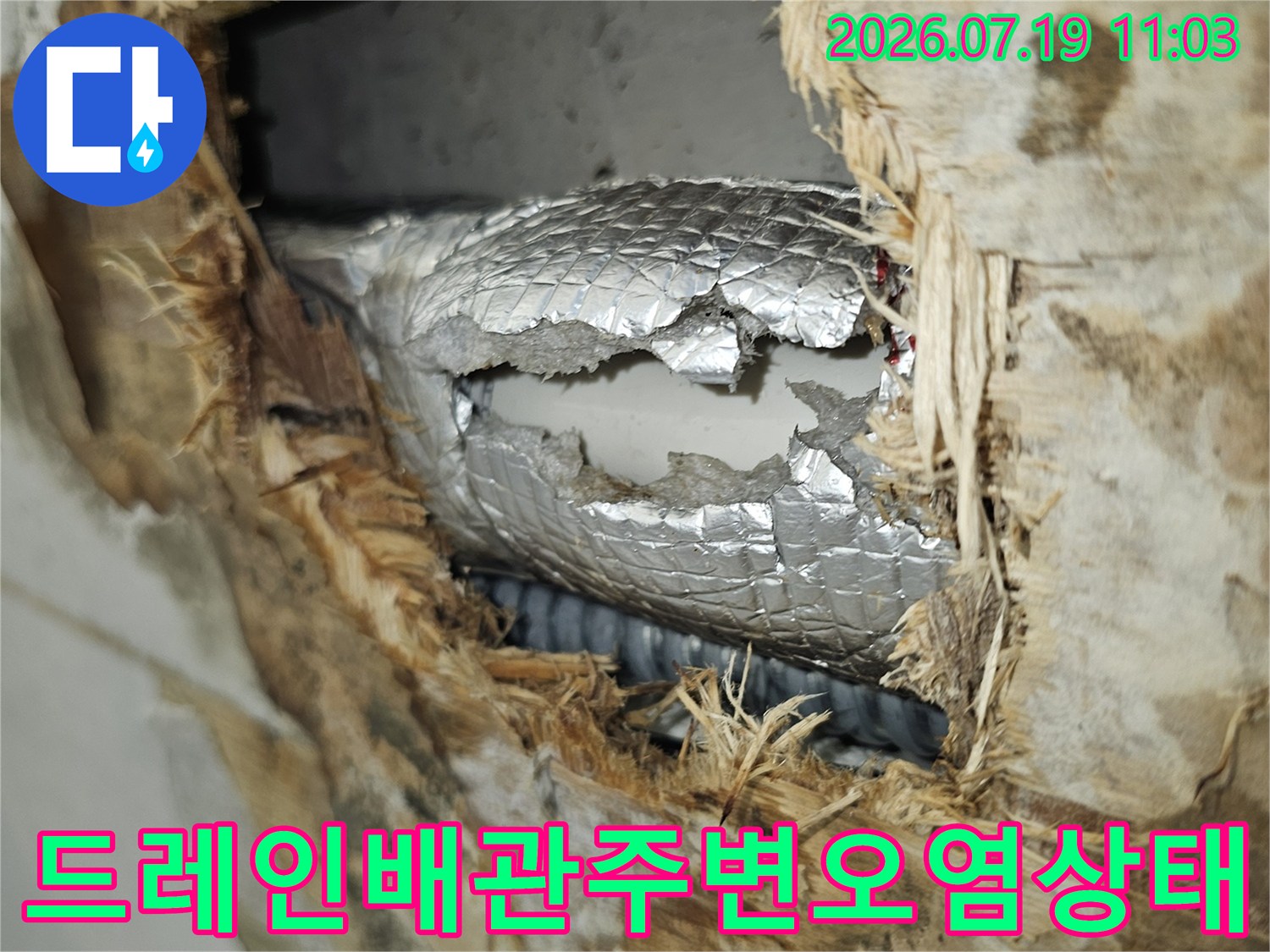 은색 단열재가 찢어지고 주변 자재들이 누수로 인해 젖어 있는 천장 내부 사진