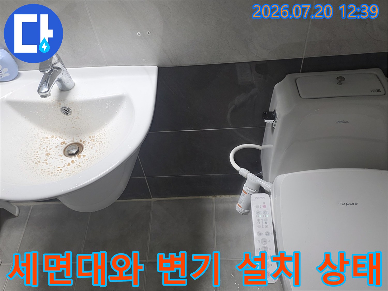 흰색 세면대의 배수구-옆에 위치한 비데 양변기 모습