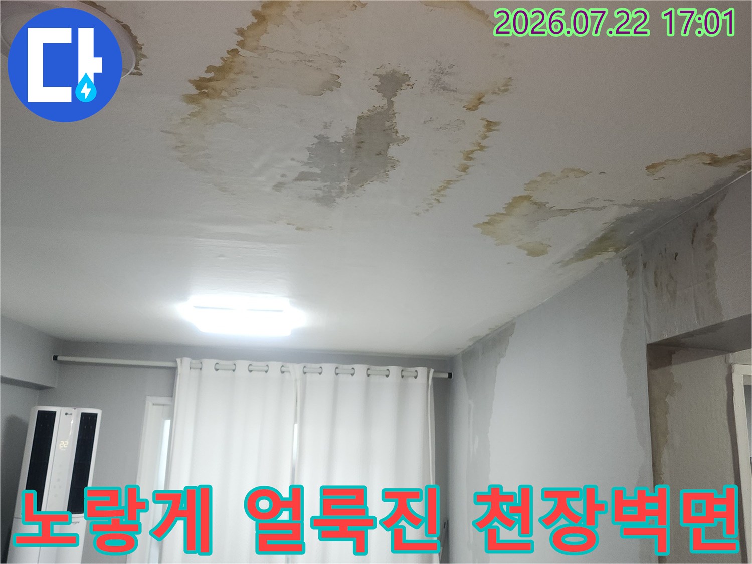 거실 천장 벽지에 남은 누수 흔적과 젖어서 일어난 도배지 모습