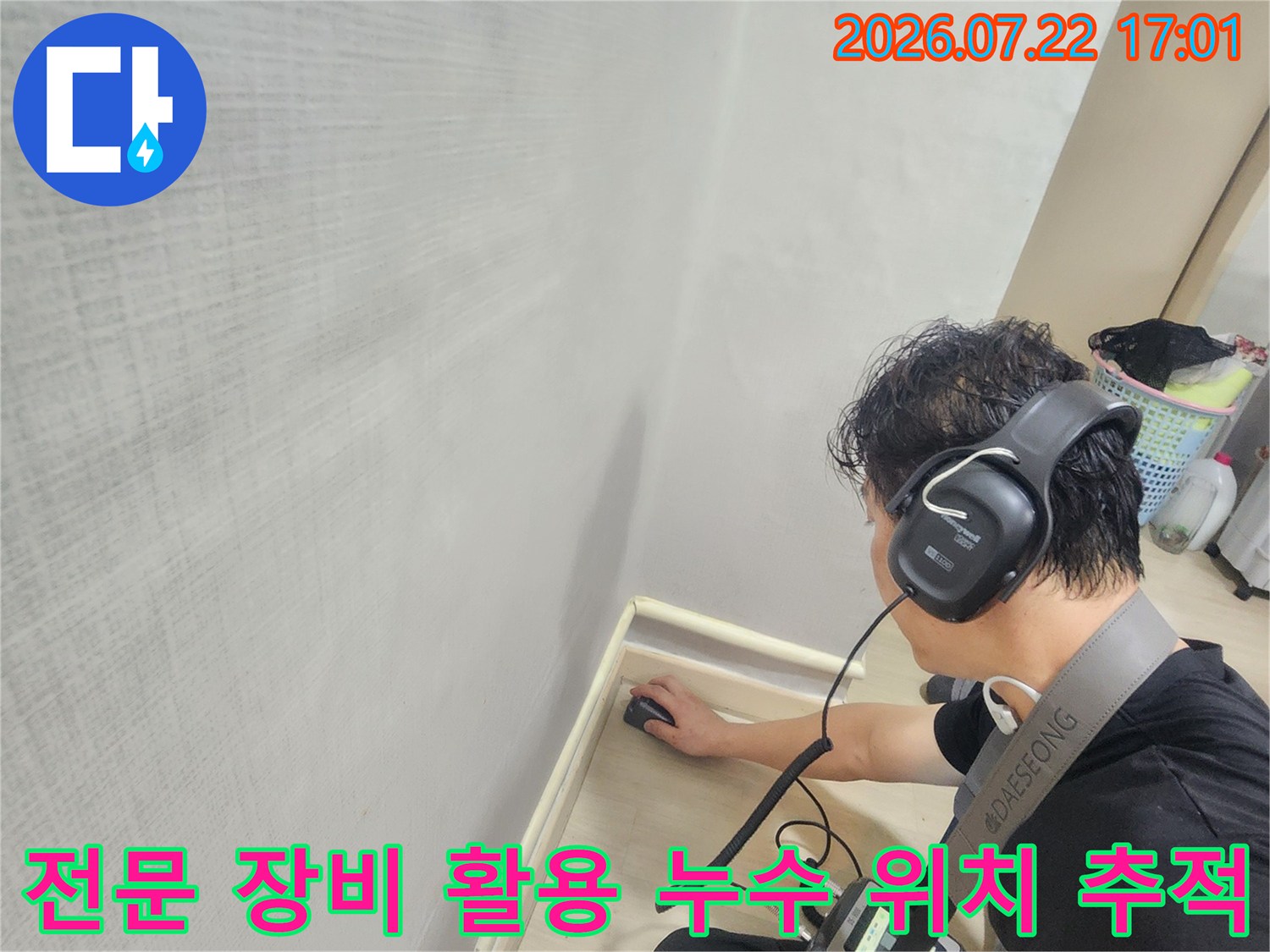 헤드셋과 청음기를 사용하여 바닥 속 배관 소리를 찾는 전문가
