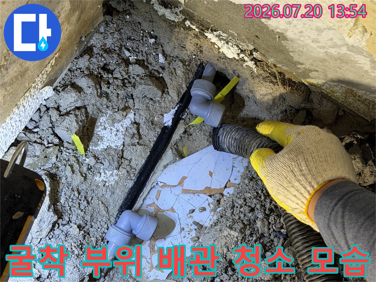 노란색-안전장갑을-착용한-작업자가-배관-주변의-먼지를-제거하는-모습