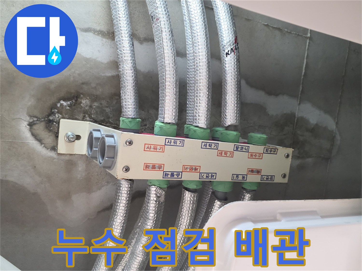 천장 내부의 은박 보온재로 감싸진 여러 개의 배관 라인