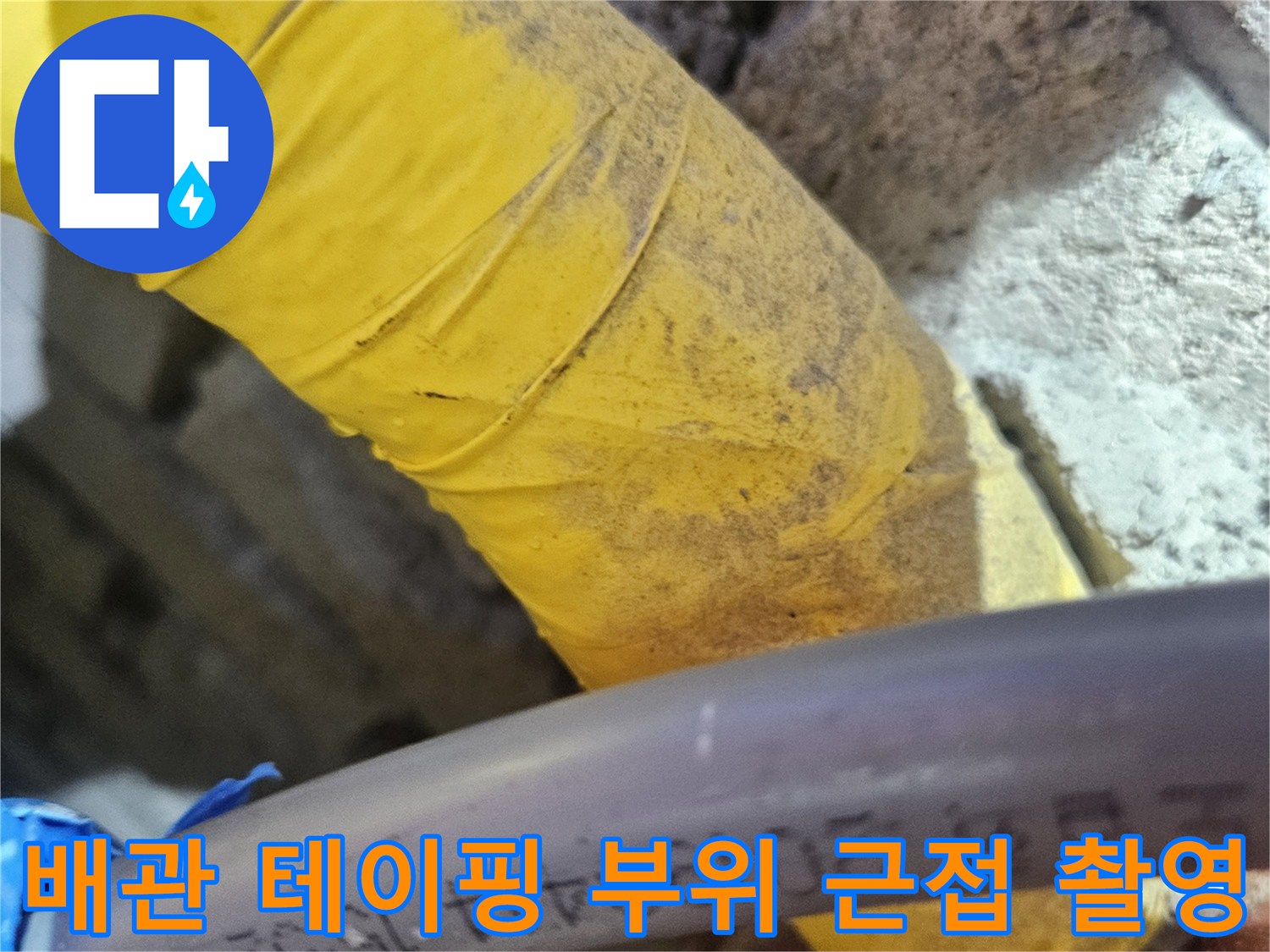 노란색 보온재가 감겨 있는 배관과 검은 호스의 접촉면