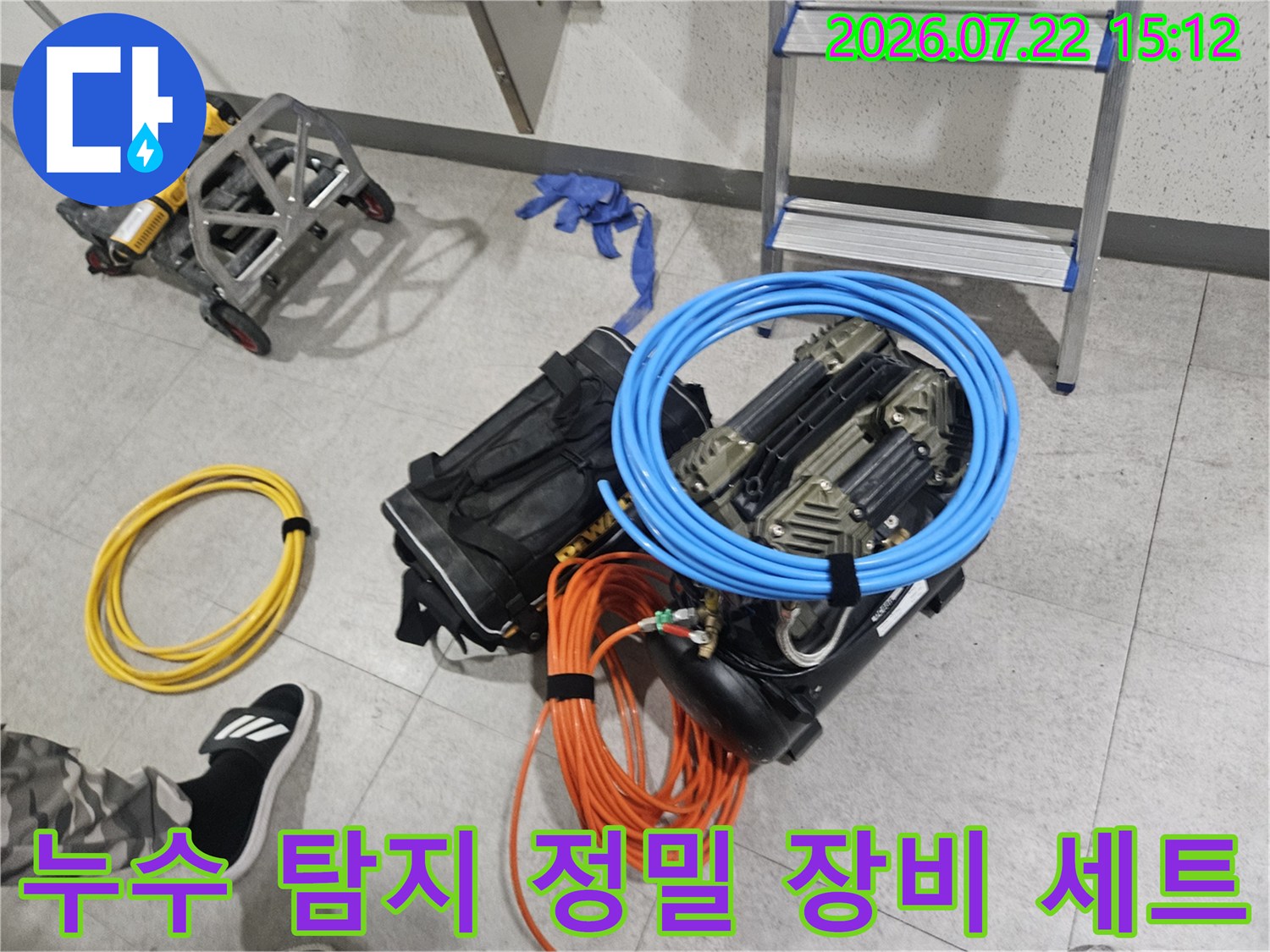 바닥에 놓인 파란색 호스와 주황색 전선 그리고 각종 누수 탐지 전문 장비들