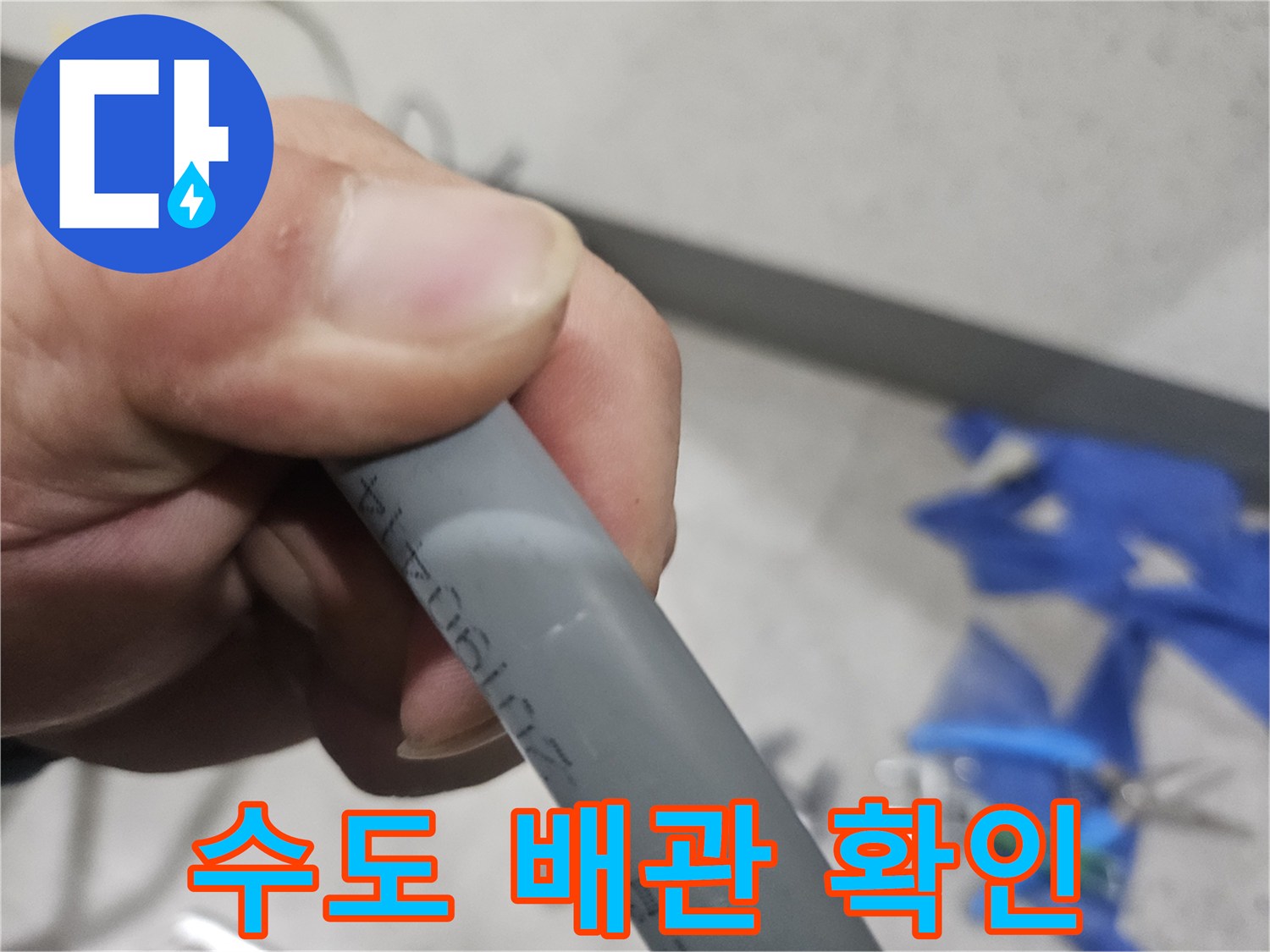 손으로 잡고 있는 회색 배관의 상태 확인