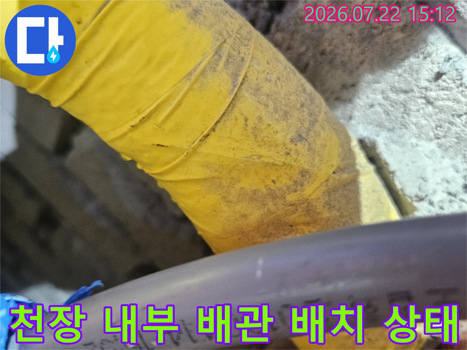 좁은-천장-공간-내부에-설치된-회색과-노란색-배관들의-모습