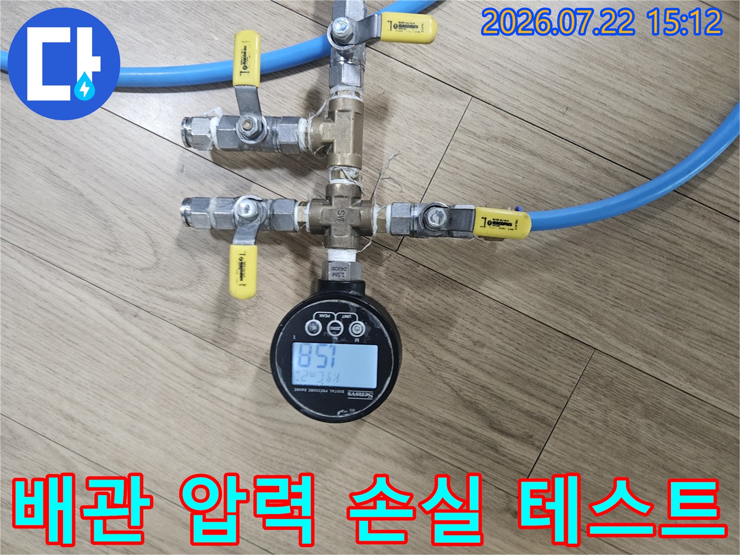 파란색 고무 호스와 황동 재질의 밸브들이 연결된 누수 진단용 공압 측정 장비 사진