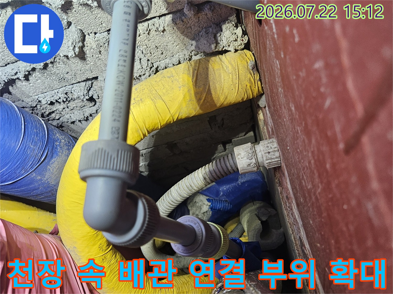 회색 엘보우 부속으로 연결된 천장 배관과 주변 보온재 모습