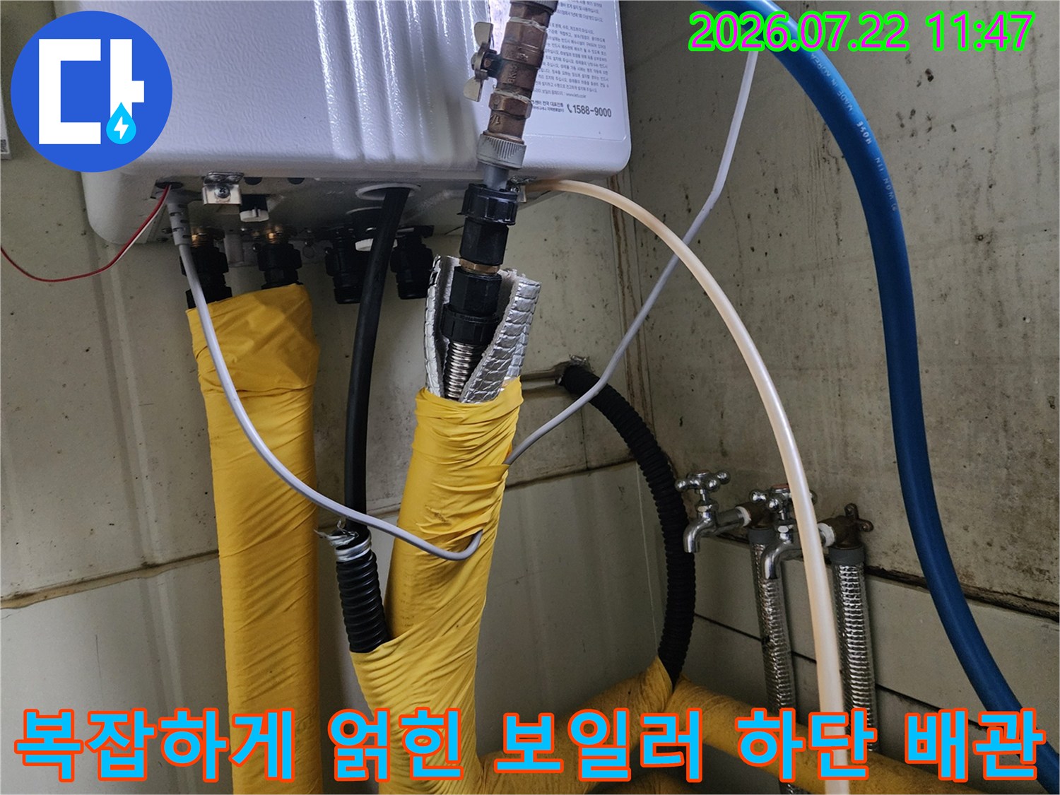 다양한 색상의 호스와 금속 연결재가 설치된 보일러 하부 배관 시스템 모습