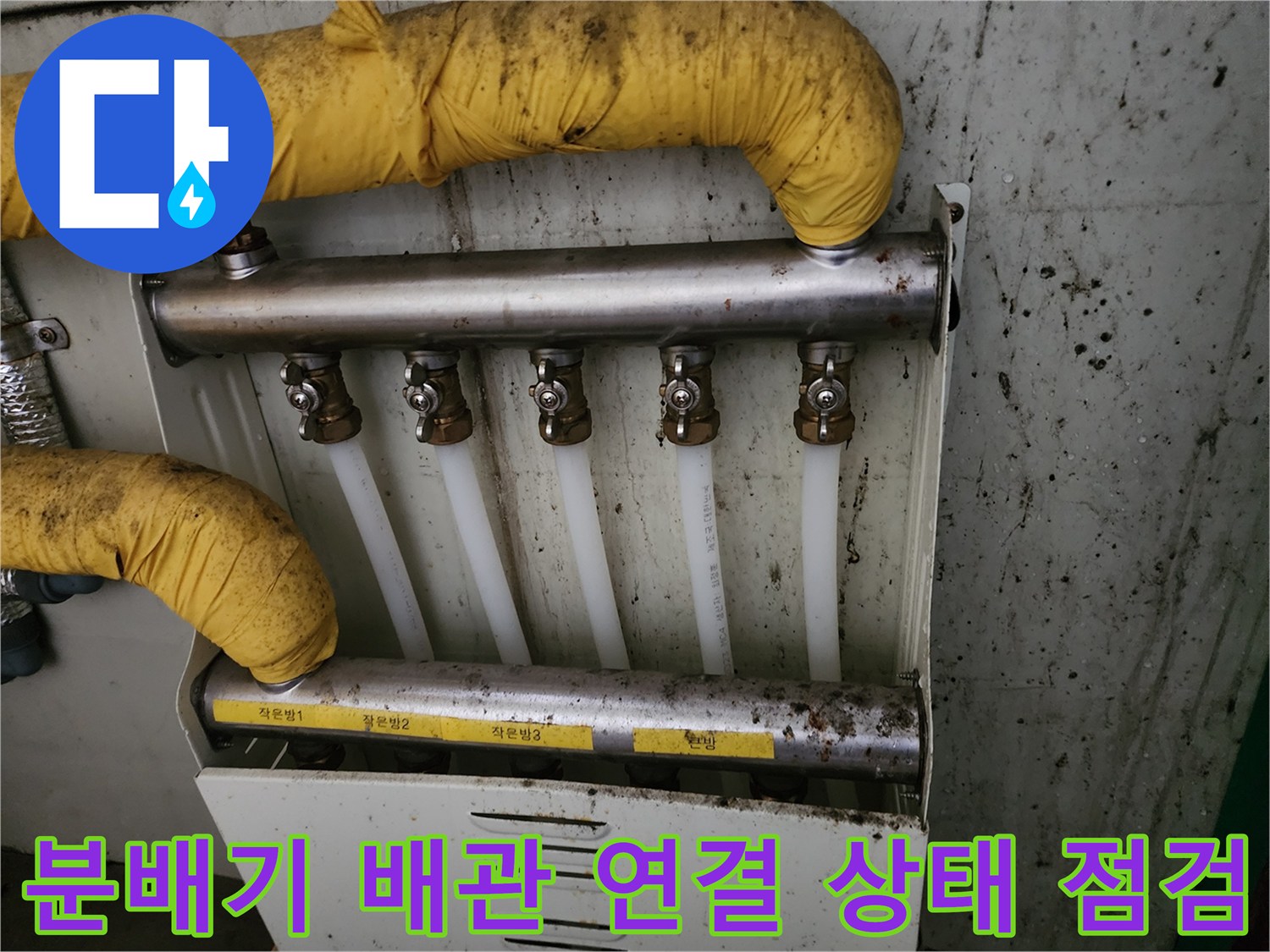 분배기에 연결된 흰색 PEX 배관과 금속 분배기 상세