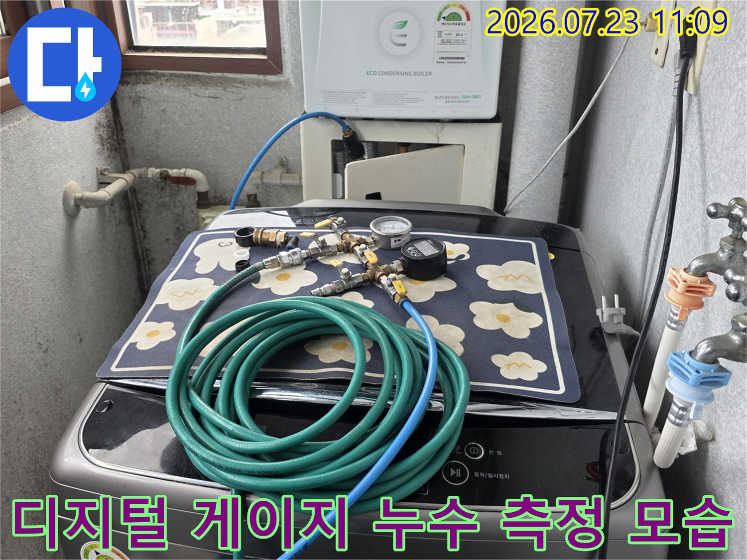 꽃무늬 매트 위에 세팅된 누수 점검용 압력 측정 장치-배관 연결 호스