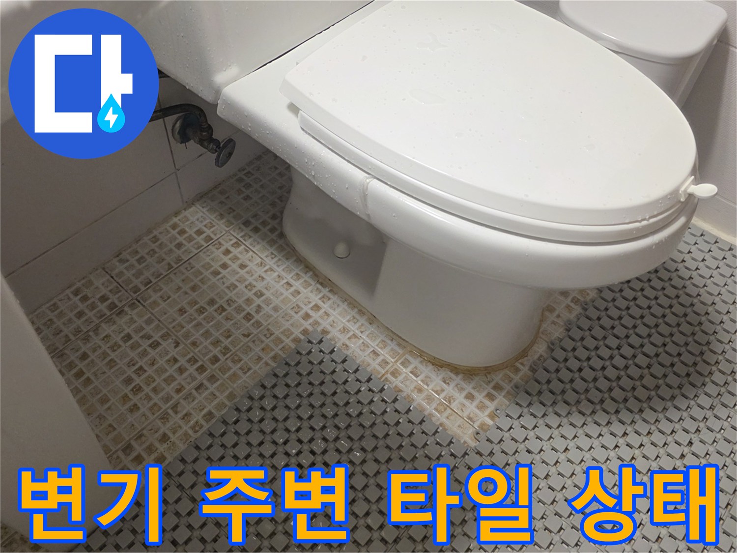 변기 하부 배관 연결 부위와 바닥 타일의 근접 모습