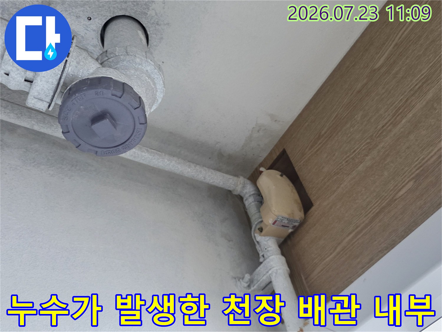 아파트 천장의 점검구를 통해 드러난 PVC 배관과 마감재의 상태를 보여주는 사진