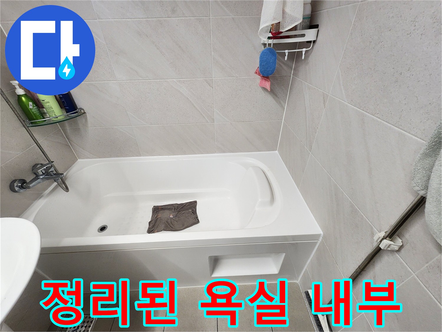 깨끗하게 정리된 화장실 욕조와 타일 벽면 모습입니다.