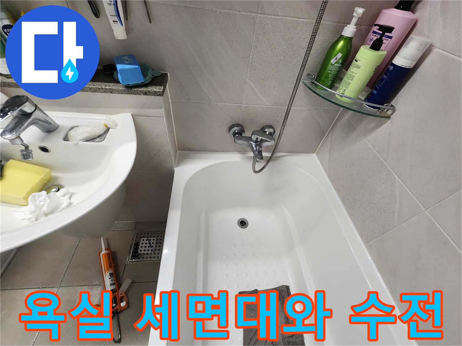 세면대 수전과 샤워기 헤드가 보이는 화장실 전경