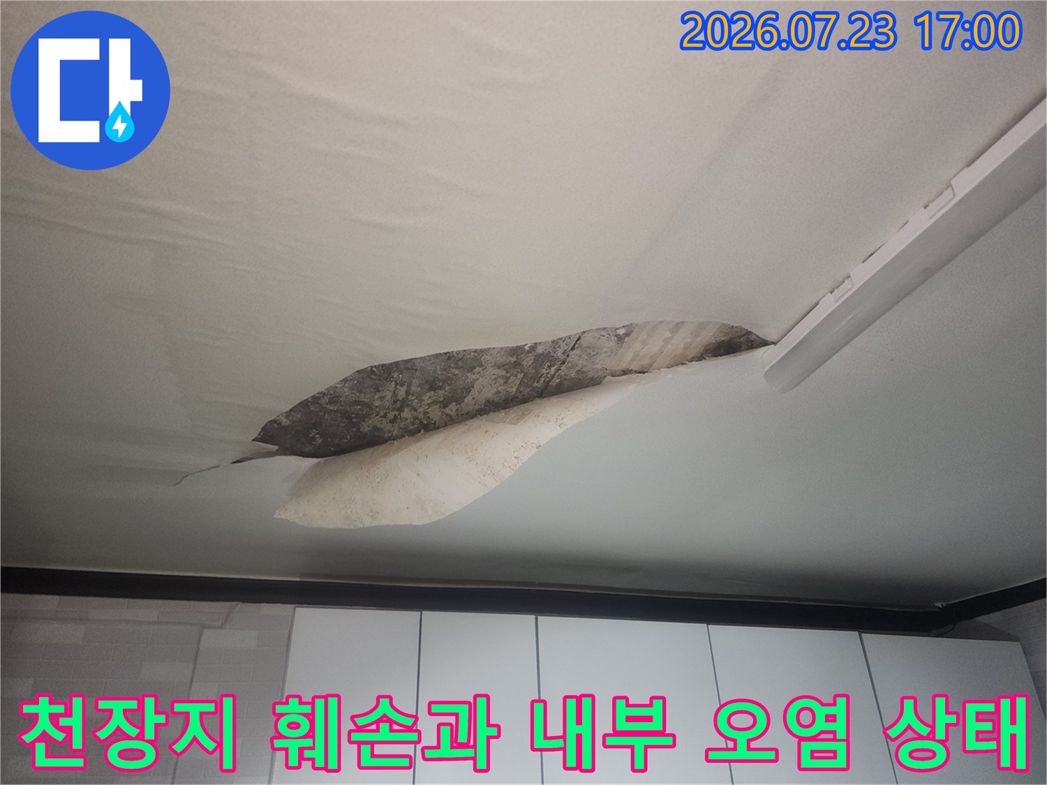 물에 젖어 아래로 처졌다가-찢어진 천장지와 어두운 콘크리트 면