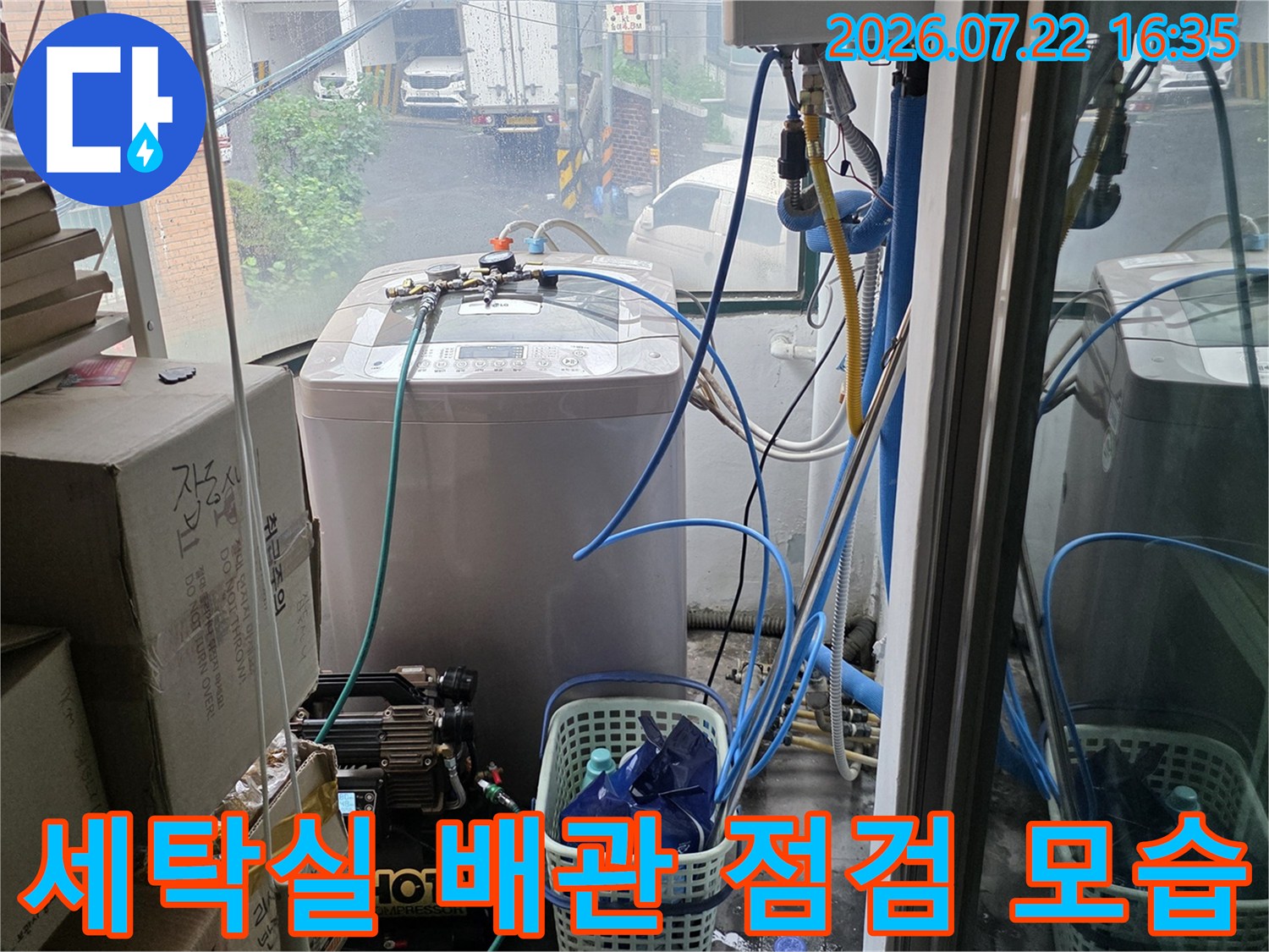 다용도실 내부에 설치된 흰색 보일러-온수기 장비와 연결된 파란색 수도 배관들