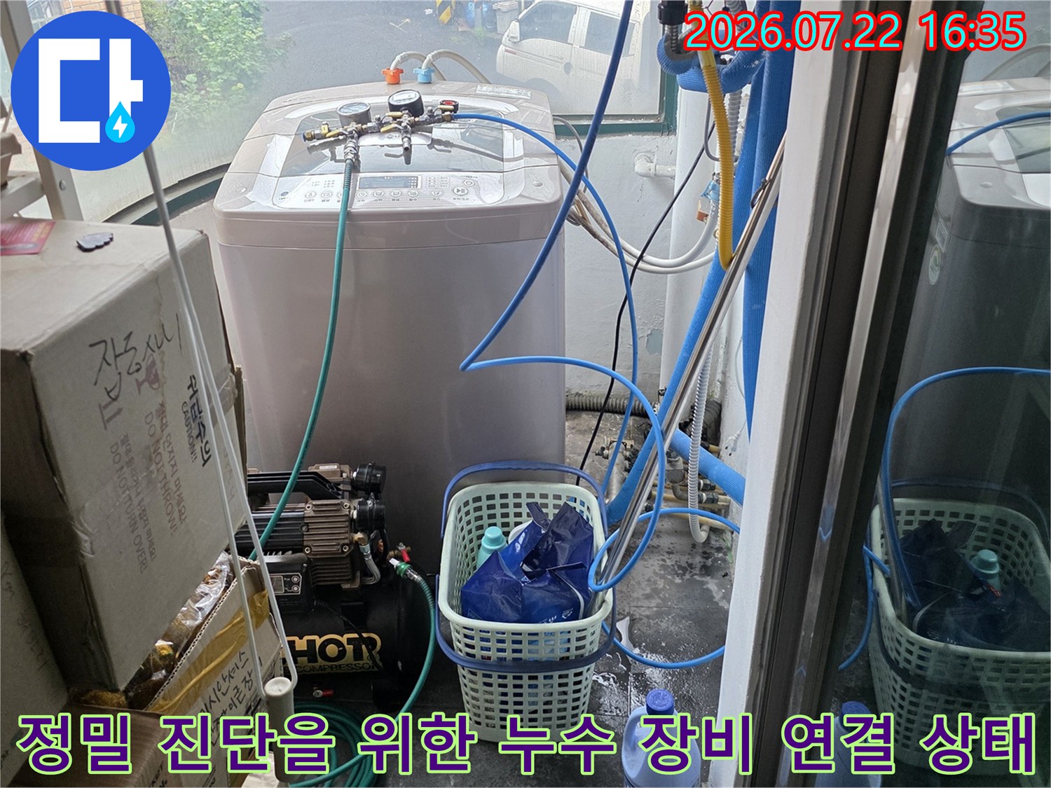 파란색 호스가 연결된 압력 측정기-세탁실 내 누수 탐지 작업 현장