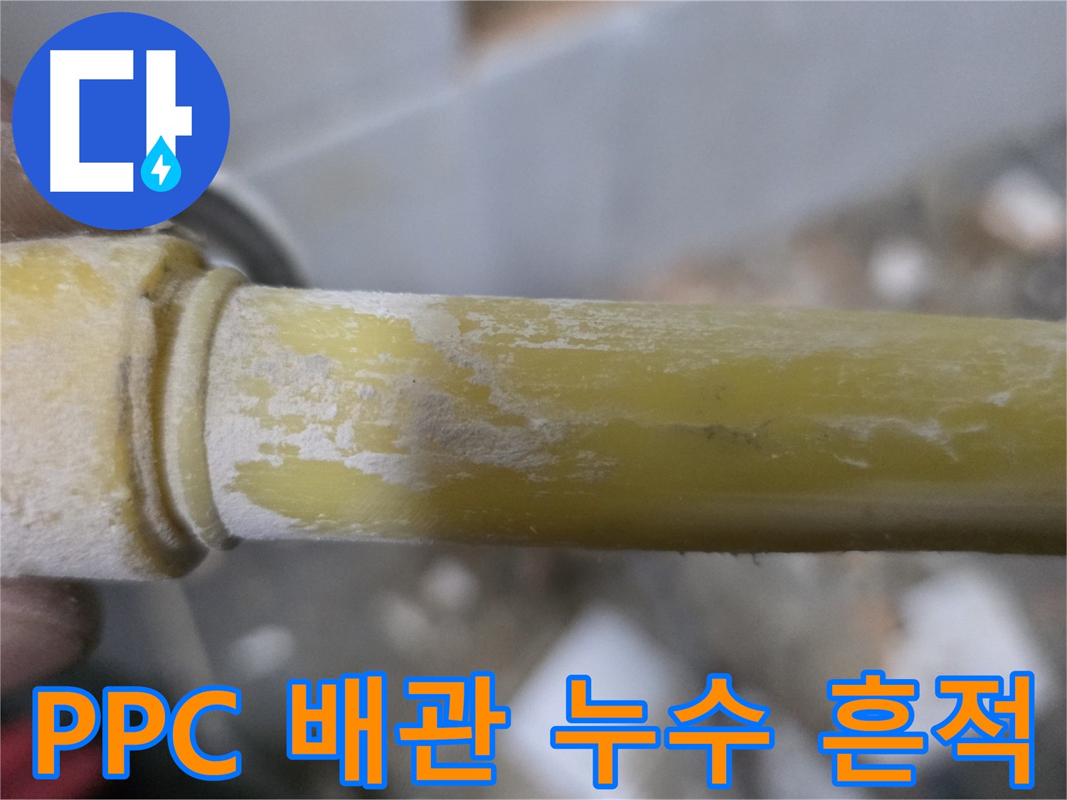 하얀 가루가 묻어 있는-노란색 수도 배관의 상세 사진입니다.