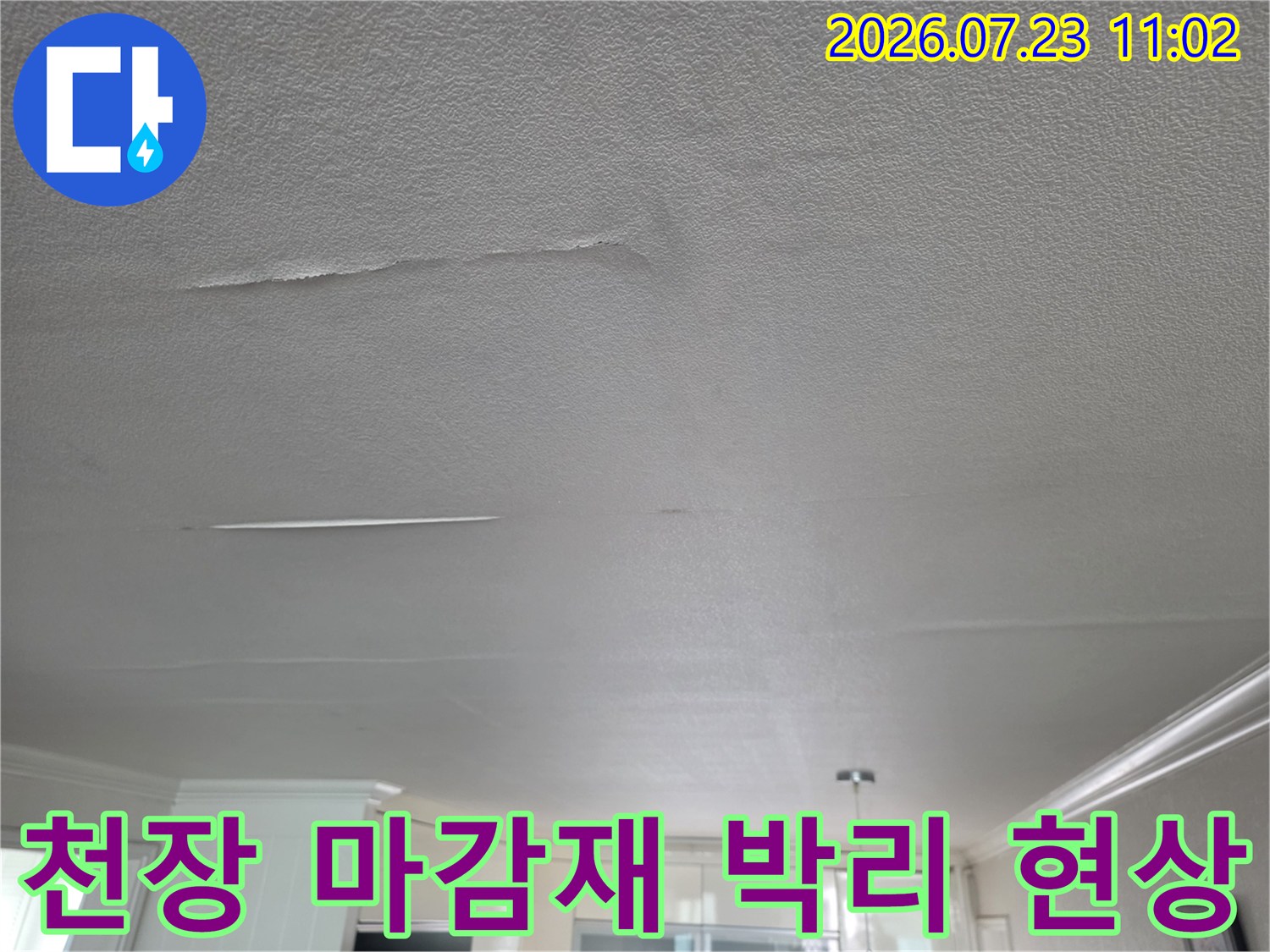 습기로 인해 하얗게 들떠서 갈라진 거실 천장의 표면 상태