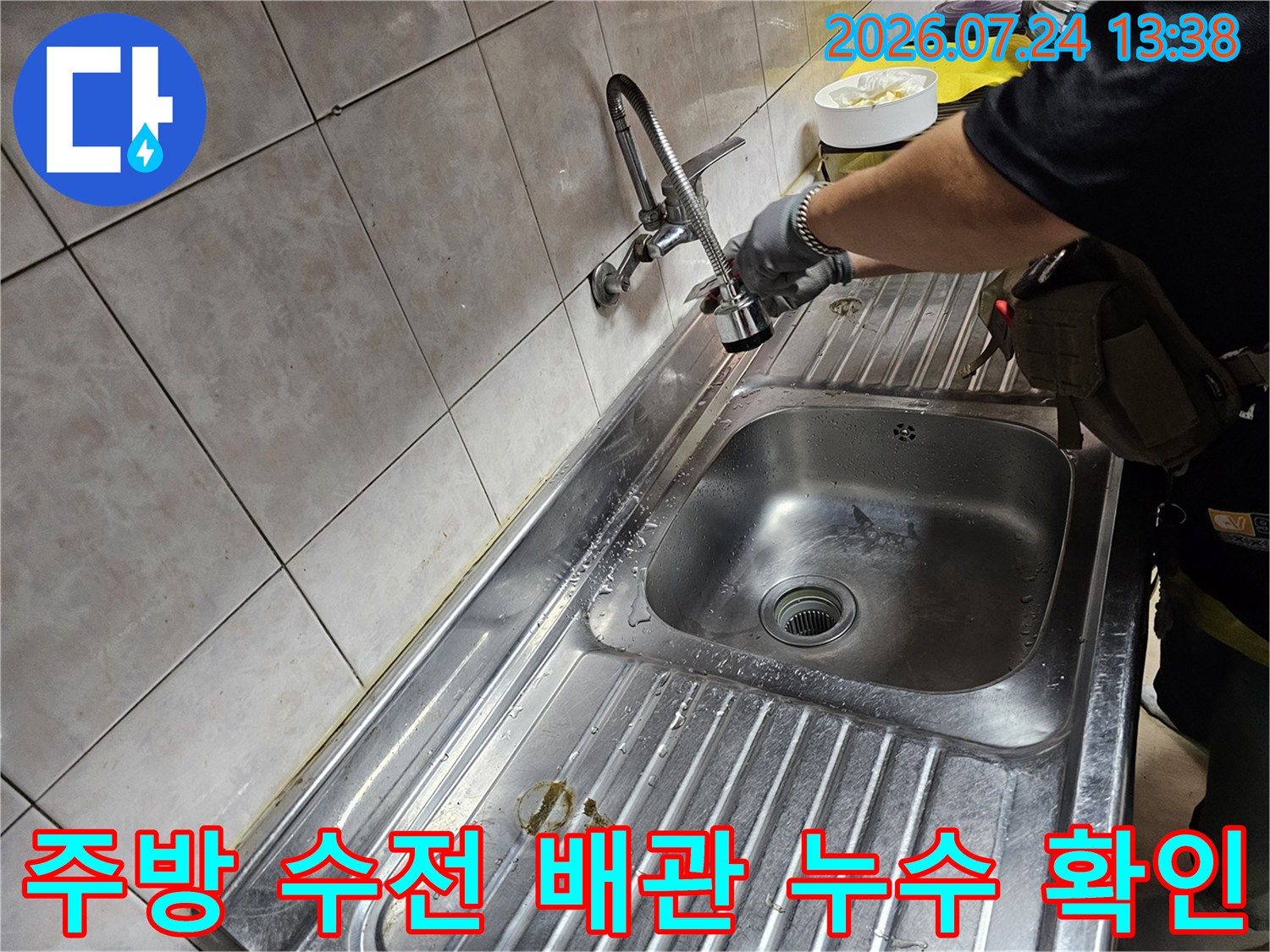 싱크대-상판-위에서-벽면-연결-배관의-부식-여부를-살피는-작업자