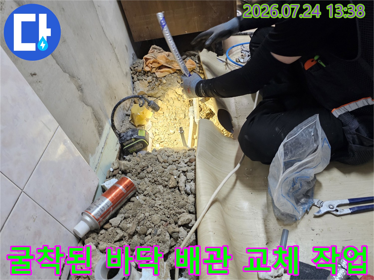 작업자가 굴착한 바닥면에서 파란색 보온재가 씌워진 배관을 연결하는 모습