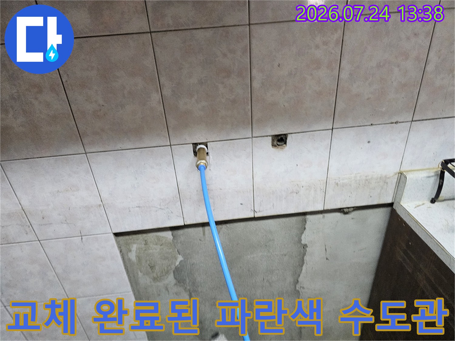 타일벽면 내부에서-새로운 파란색 배관이 연결되어 밖으로 나온 모습
