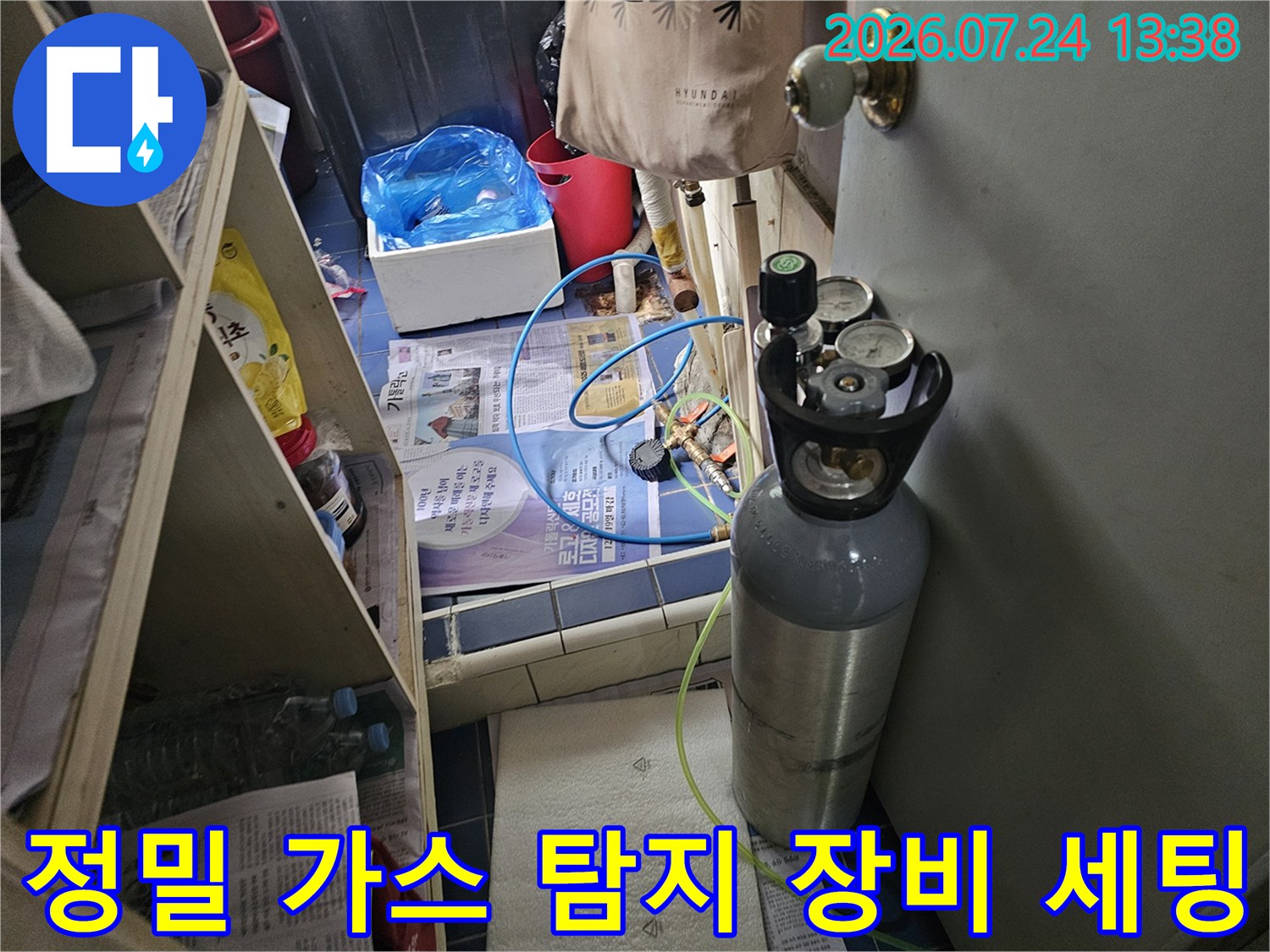 회색 금속 탱크와-압력 게이지-그리고 연결된 파란색 호스의 모습