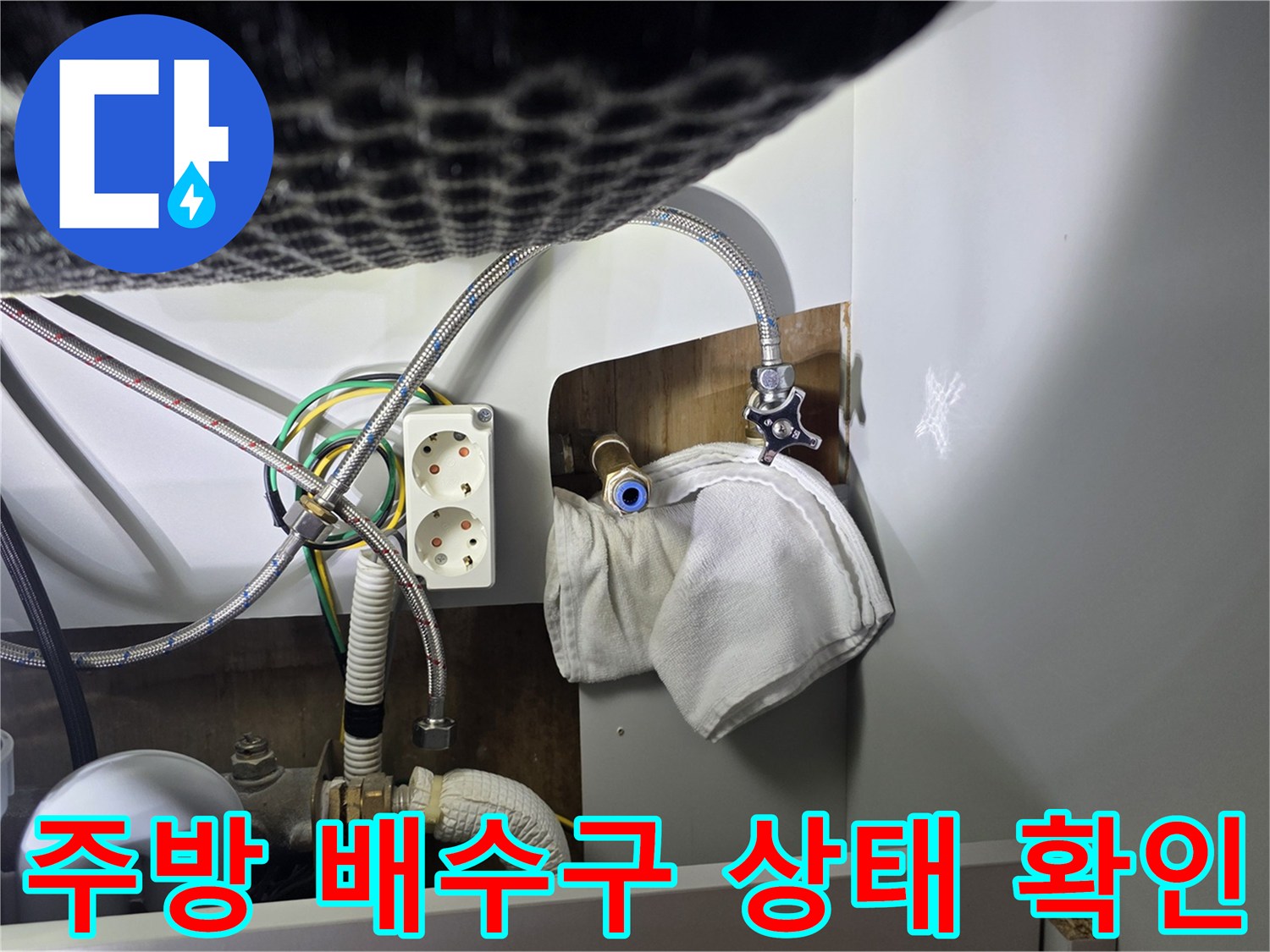 주방 싱크대 하부의 배수 호스와 수도 연결 관로 모습