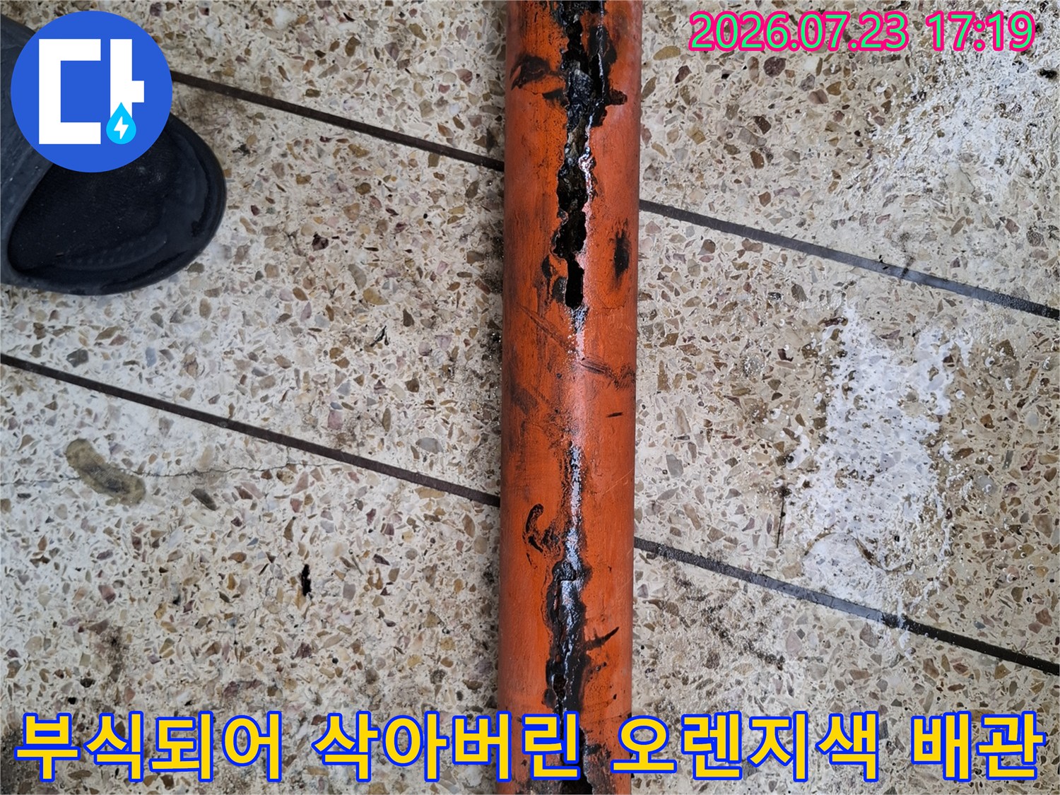 오렌지색 배관 표면이 부식되어 군데군데 구멍이 난 상태의 근접 사진