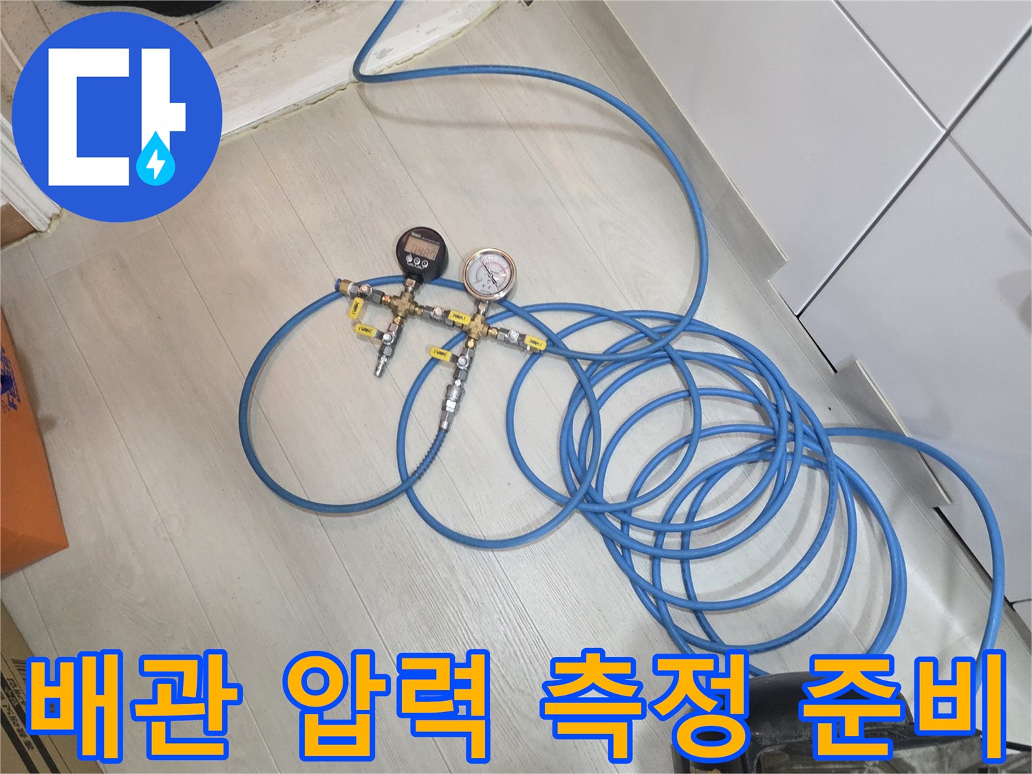 바닥에 배치된 파란색 에어 호스와 압력계