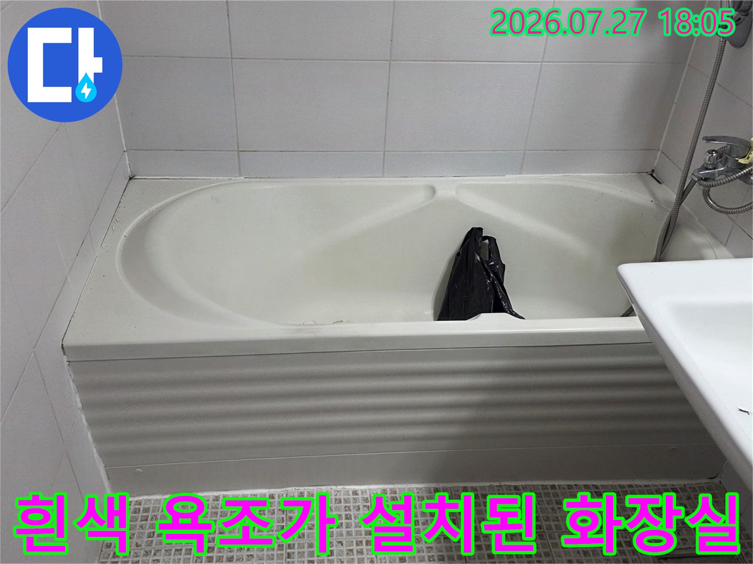 욕실 내부에 설치된 흰색 매립형 욕조-우측에는 세면대가 위치함