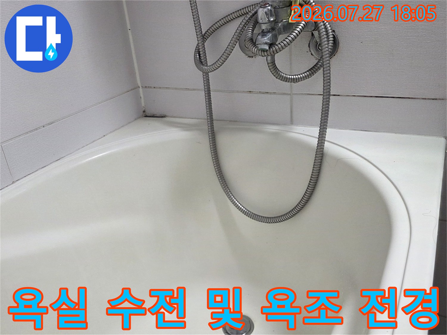 흰색 타일 벽면과 욕조 그리고 샤워기가 설치된 화장실 내부 사진