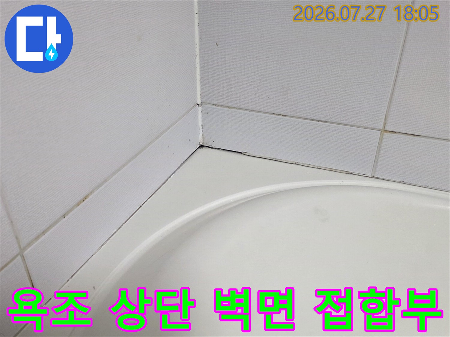 흰색 타일과 욕조가 만나는 모서리 부분의 상세 모습 사진