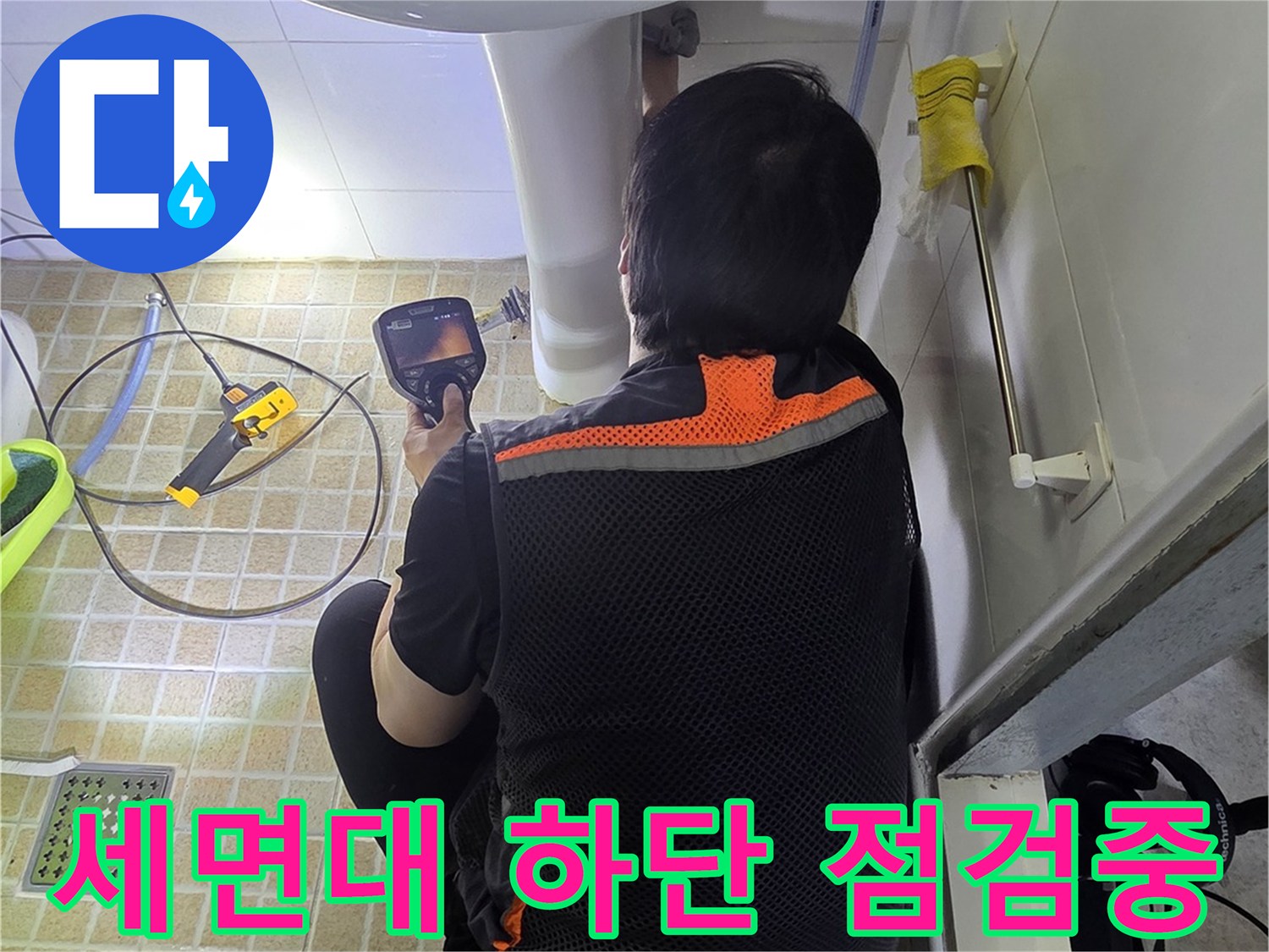 세면대 아래쪽 배관 부위를 면밀히 조사하는 엔지니어의 모습