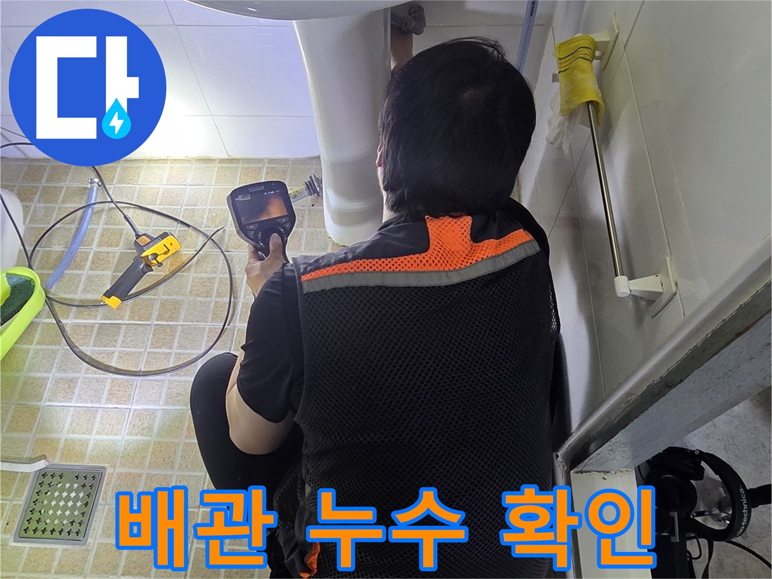 세면대 하단 배관의 연결 상태를 면밀히 조사하는 모습