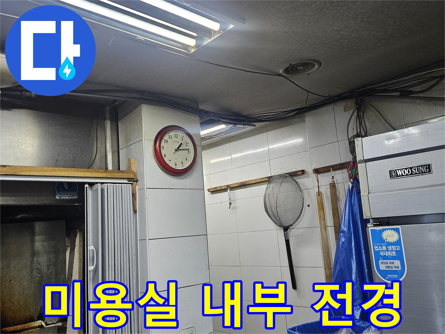 흰색 타일벽과 냉장고가 있는 미용실 샴푸 구역입니다.