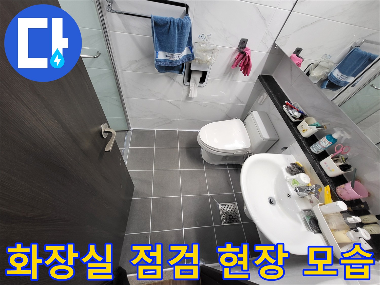 변기와 세면대가 설치된 화장실 내부의 전체적인 전경입니다.
