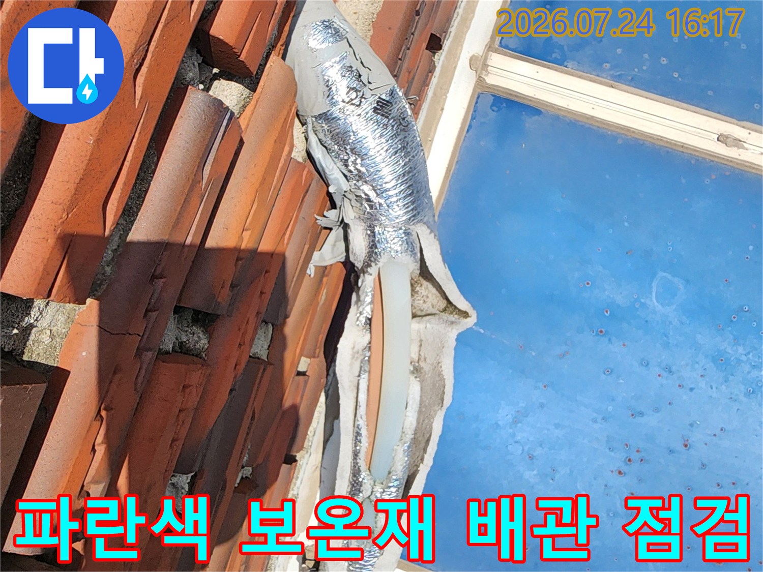 노출된 파란색 단열재와 붉은 벽돌 마감면의 대조