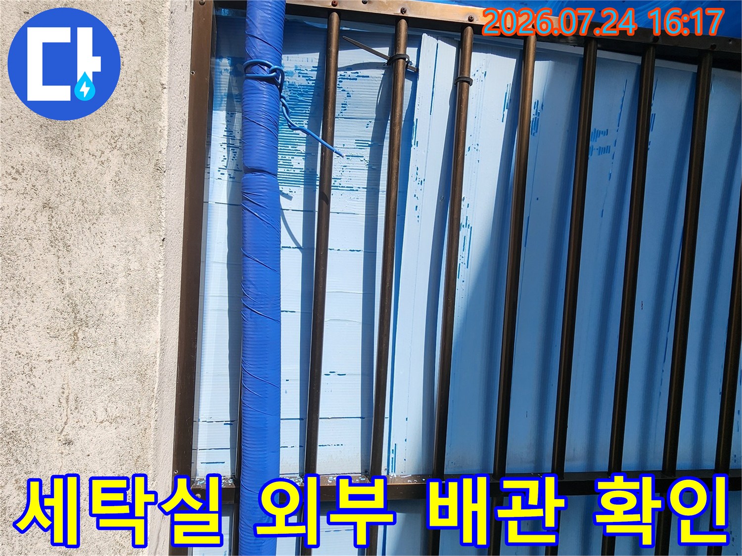 다용도실 외부로 노출된 파란색 보온재 배관의 전경