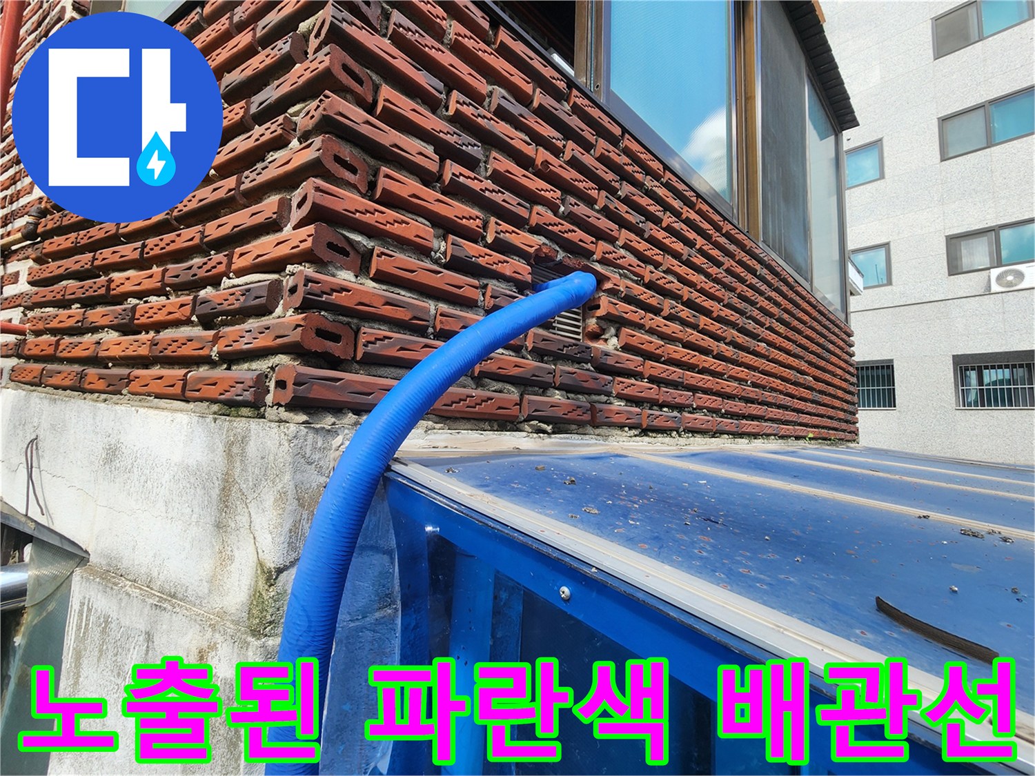 벽돌 벽면 사이로 나온 파란색 보온재 마감된 수도 배관