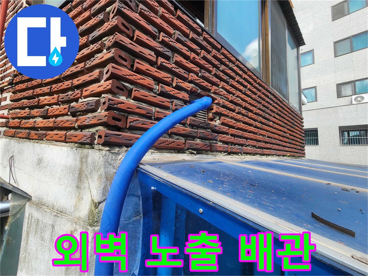 벽돌 벽면을 따라 설치된 파란색 보온재가 씌워진 수도 배관