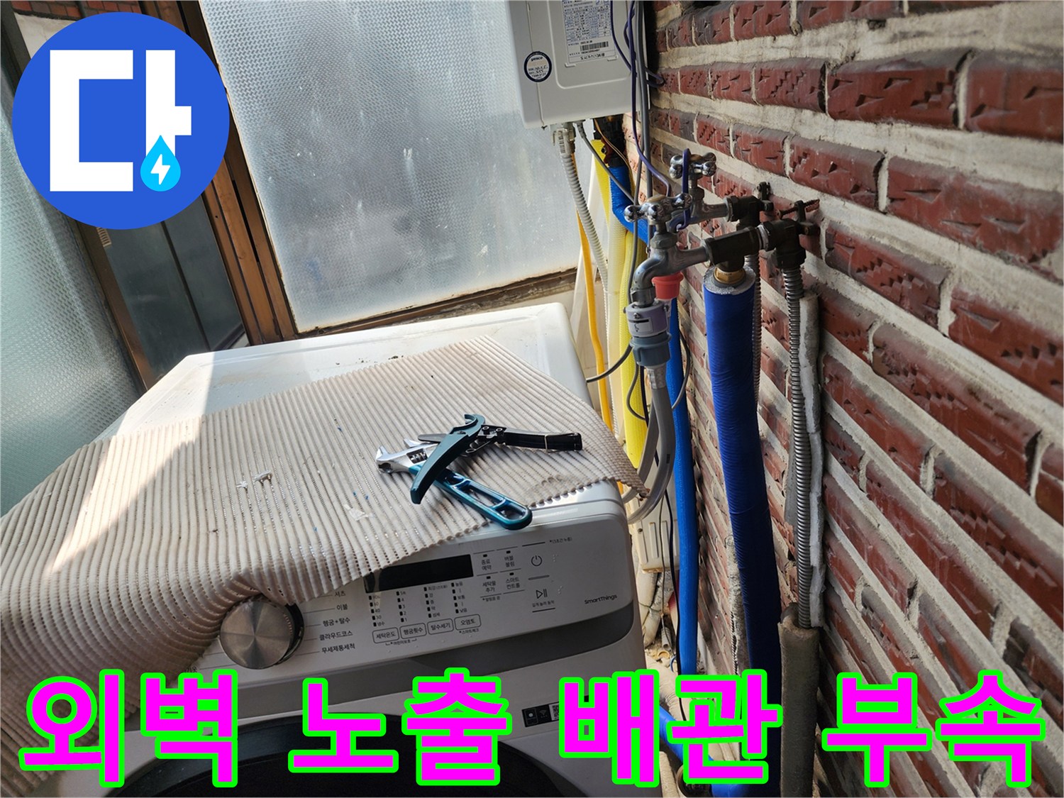 벽돌 외벽의 파란색 배관과 금속 연결 밸브 상세 사진