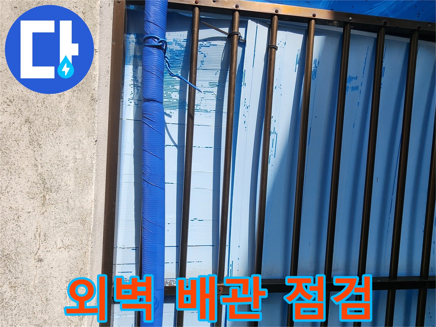 창살 구조물 뒤편의 파란색 보온재 덮인 배관입니다.