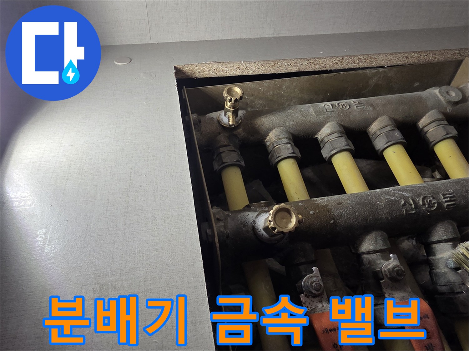분배기 내부-금색 퇴수 밸브와 배관 연결부